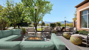 An outdoor seating area with sofas, chairs, and a fire feature.