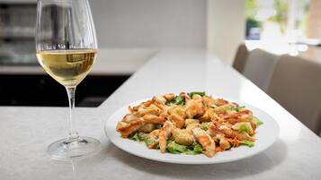 A dining table with a plate of food and a wine glass.