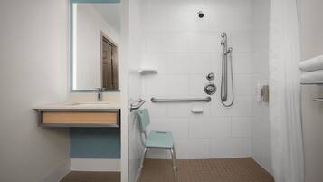Un baño con ducha, lavamanos y una silla.