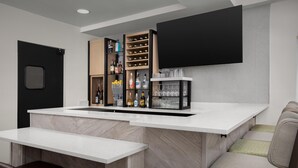 A modern kitchen with a bar area, built-in wine racks, and a flat-screen TV. - Hilton Garden Inn Colorado Springs North Air Force Academy (Colorado Springs)