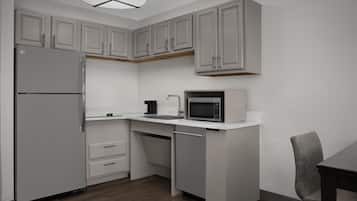 A compact kitchen with a refrigerator, microwave, and sink.