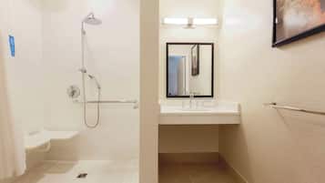 Ein Badezimmer mit Dusche, Waschbecken und Spiegel.