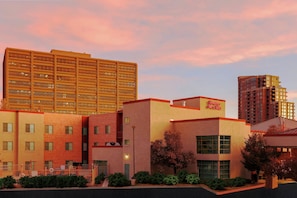 A hotel with multiple floors, a prominent sign for Hampton Inn & Suites, and a parking lot with a fence. - Hampton Inn & Suites Denver Tech Center (Denver)
