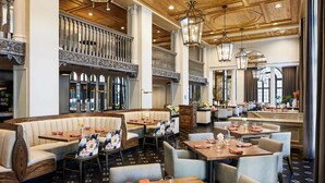 A spacious restaurant with high ceilings, ornate columns, and a variety of seating options including booths and tables. - The Terrace Hotel Lakeland, Tapestry Collection by Hilton (Lakeland)