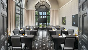 A conference room with a black and white checkered floor, large windows with curtains, and a chandelier. - The Terrace Hotel Lakeland, Tapestry Collection by Hilton (Lakeland)