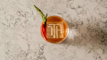 A glass with a golden emblem on a marble surface.