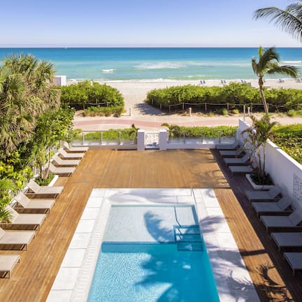 A rooftop pool with a view of the beach and ocean.