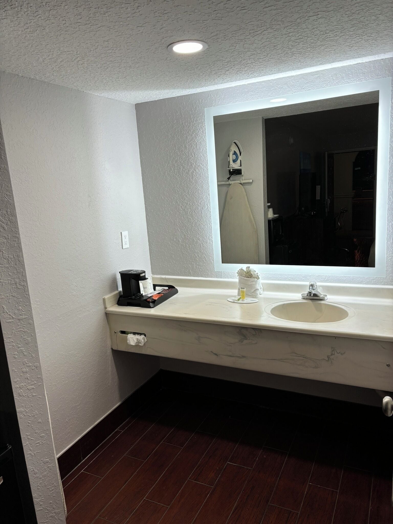 A bathroom with a white marble sink, a mirror, and a window.