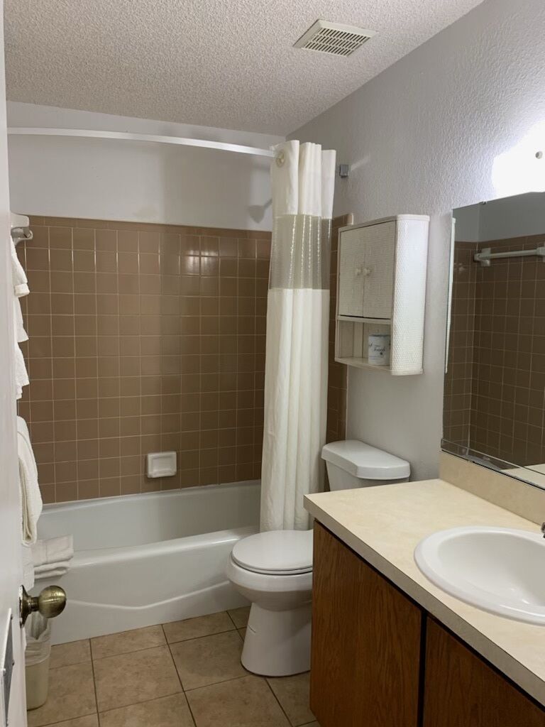 A bathroom with a bathtub, toilet, and sink.