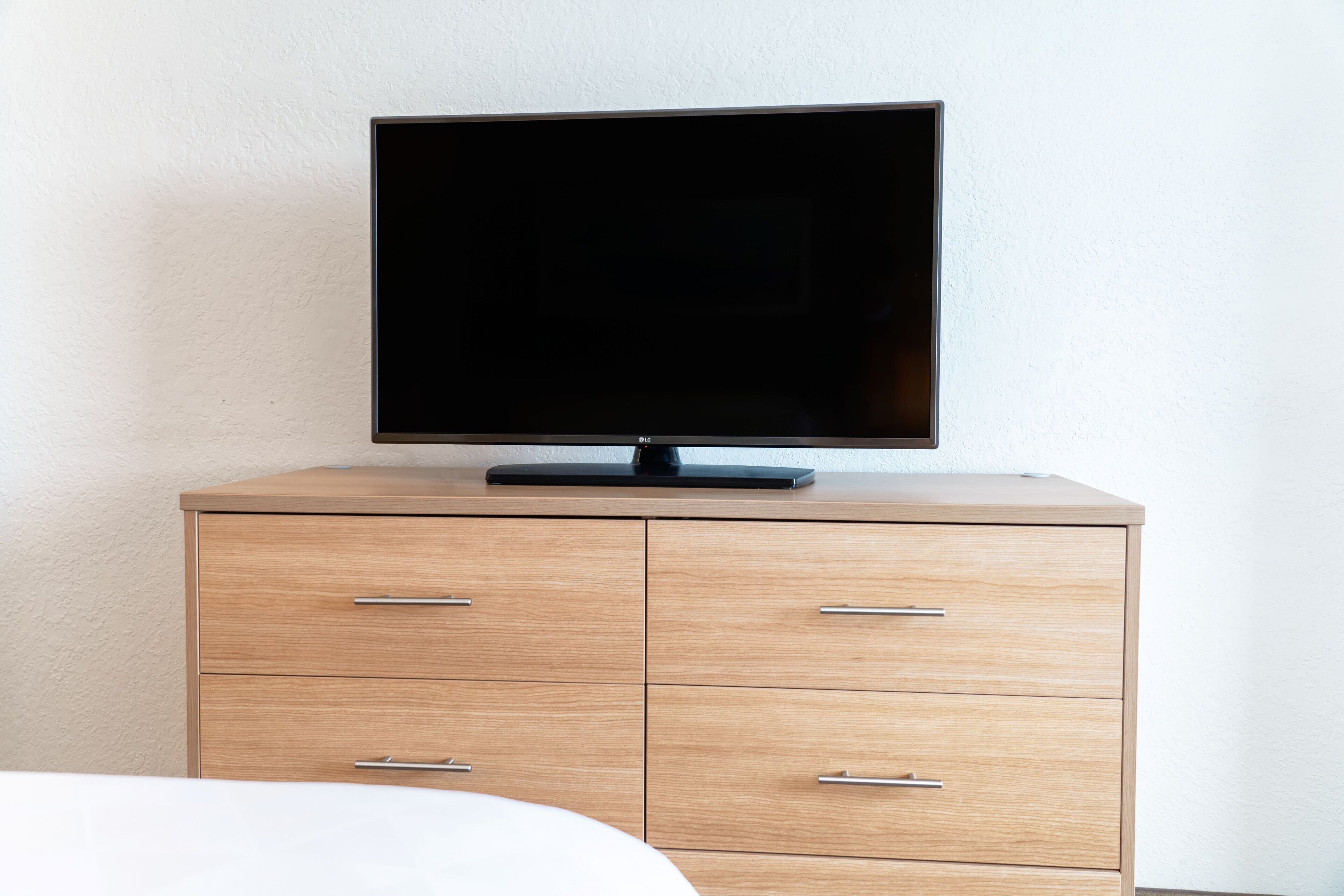 Een televisie op een houten dressoir in een hotelkamer.