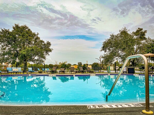 Una piscina al aire libre, sillones reclinables de piscina