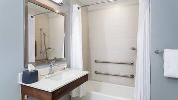 A modern bathroom with a shower, a sink with a mirror, and a bathtub.