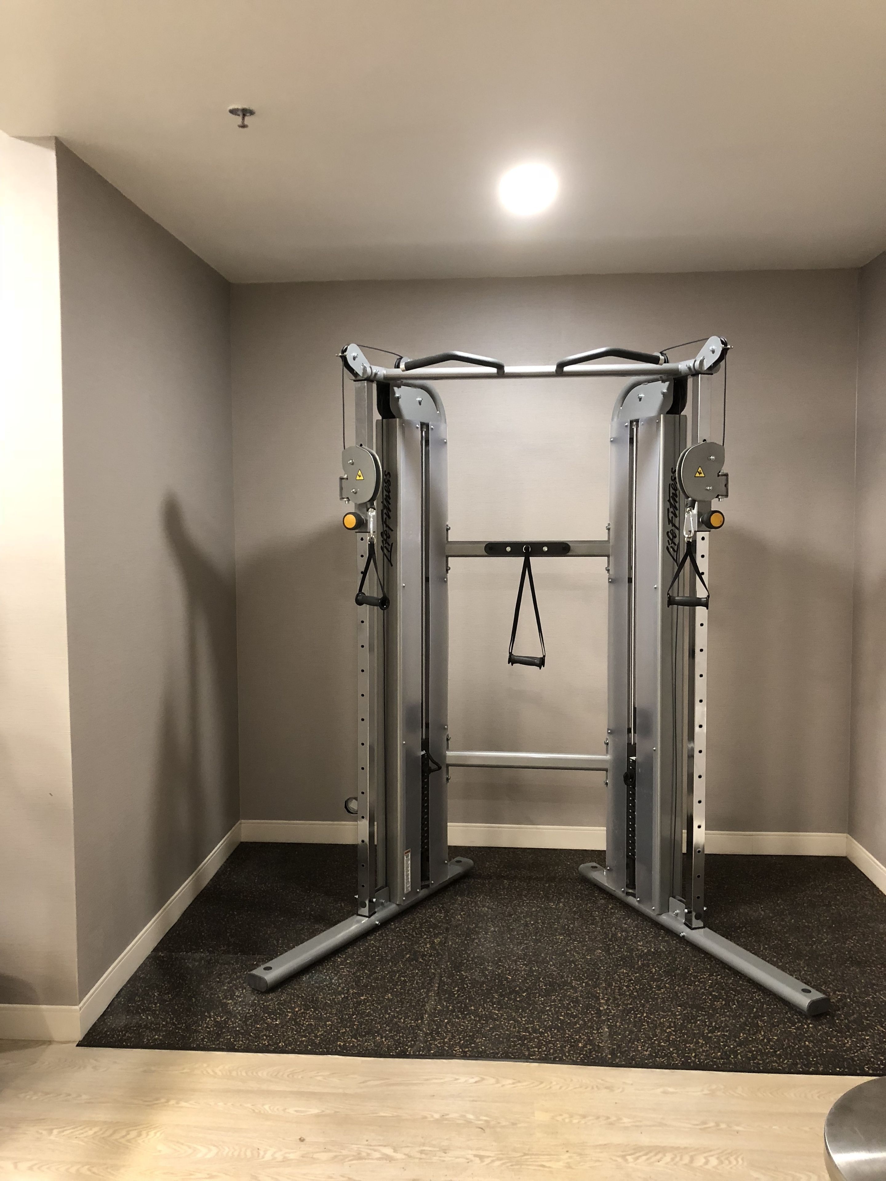 Een fitnessruimte met een pull-up bar en krachtapparaten.