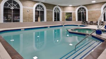 An indoor swimming pool with clear water, tiled edges, and a brick border.