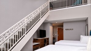 A hotel room with a staircase, a television, a bed, and a desk. - Hampton Inn & Suites Boise/Spectrum (Boise)