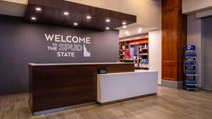 A reception desk with a 'Welcome to the SPUD State' sign, a minibar, and a water dispenser. - Hampton Inn & Suites Boise/Spectrum (Boise)