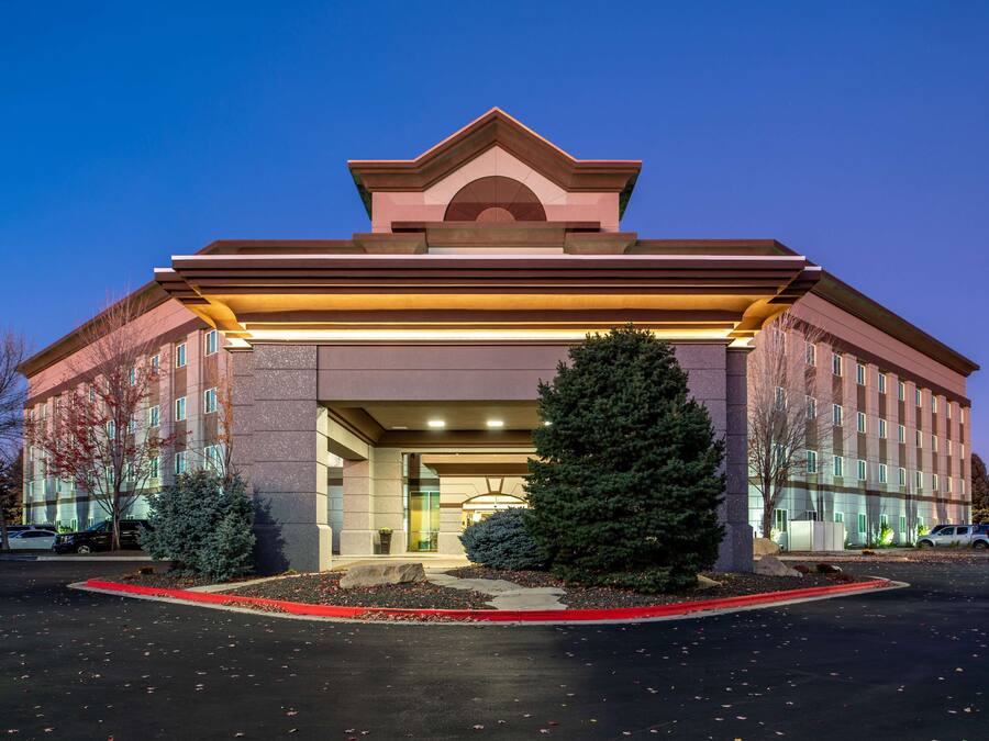 A multi-story hotel with a prominent entrance, large windows, and a well-lit facade.