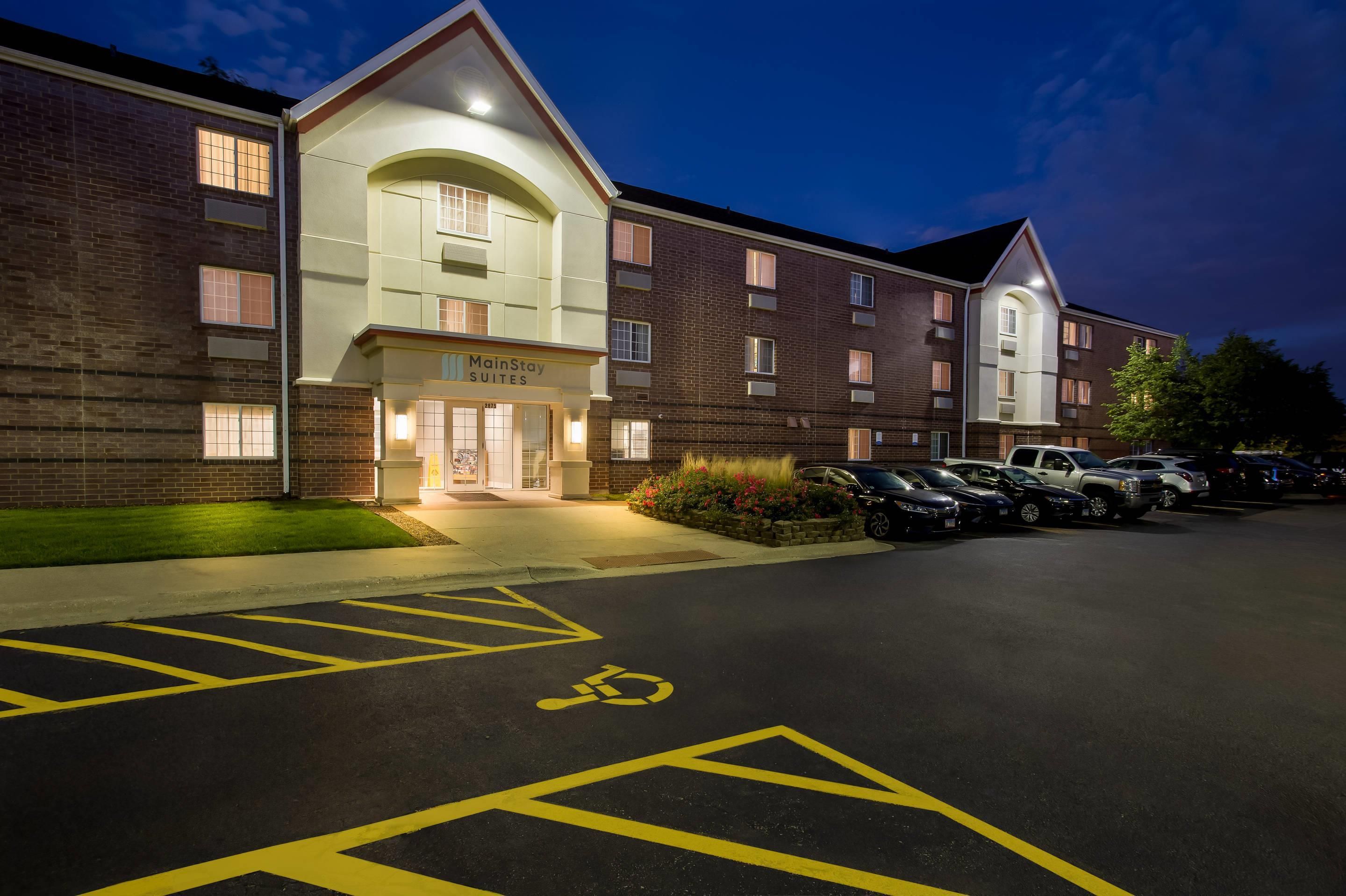 Hotel MainStay Suites con estacionamiento, espacios para discapacitados señalizados y fachada de ladrillo.