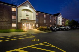 Hotel MainStay Suites con estacionamiento, espacios para discapacitados señalizados y fachada de ladrillo.