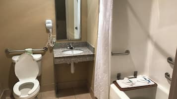 Un baño con inodoro, lavamanos, espejo y bañera.