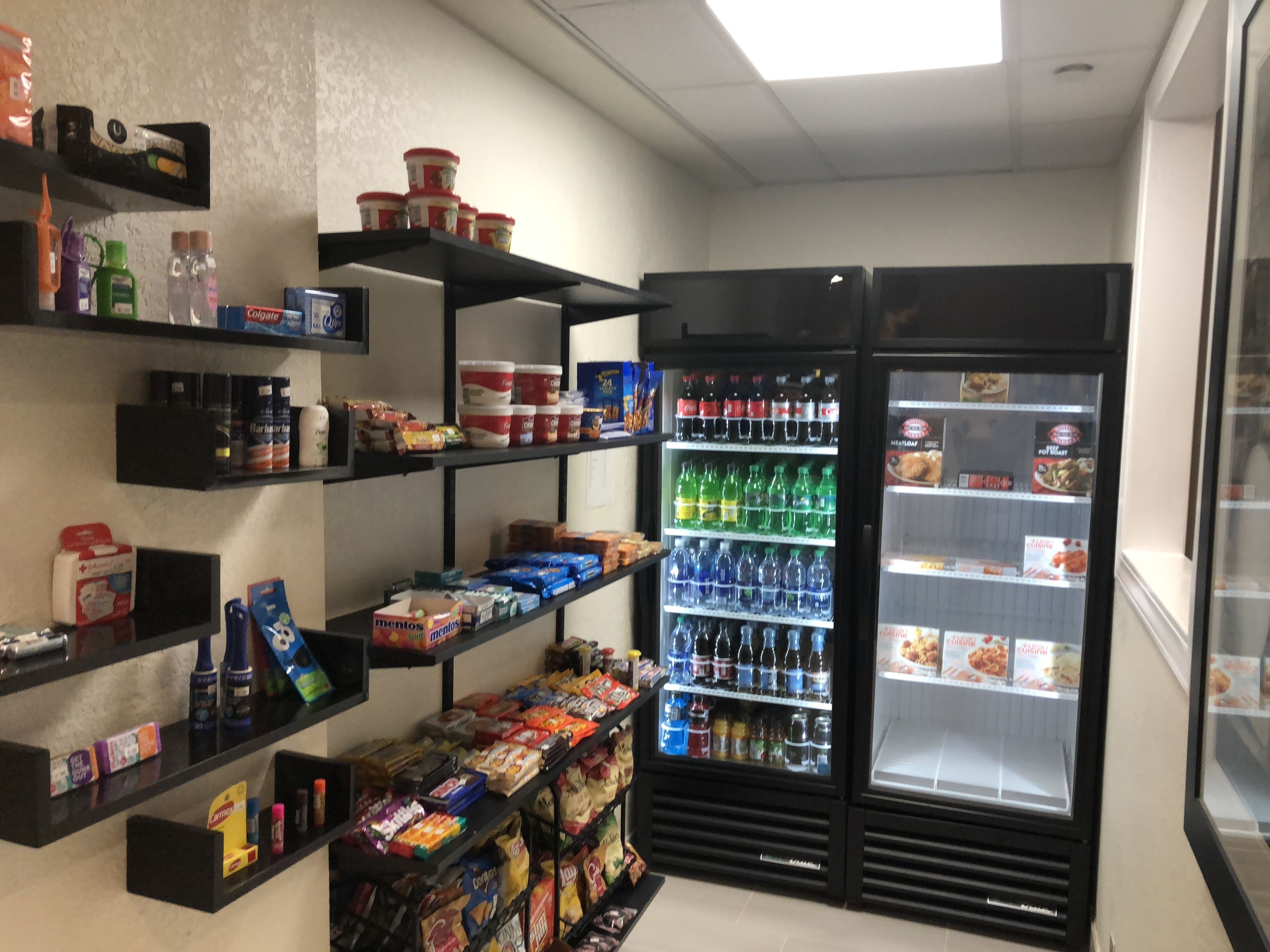 A small convenience store with shelves stocked with snacks, beverages, and household items.