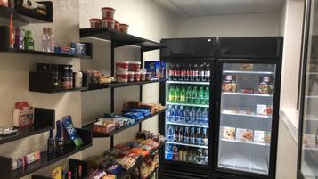 A small convenience store with shelves stocked with snacks, beverages, and household items.
