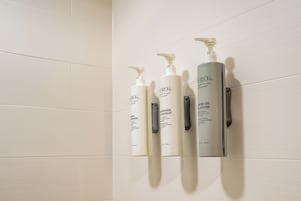 Tres productos para el cuidado de la piel exhibidos en una pared.