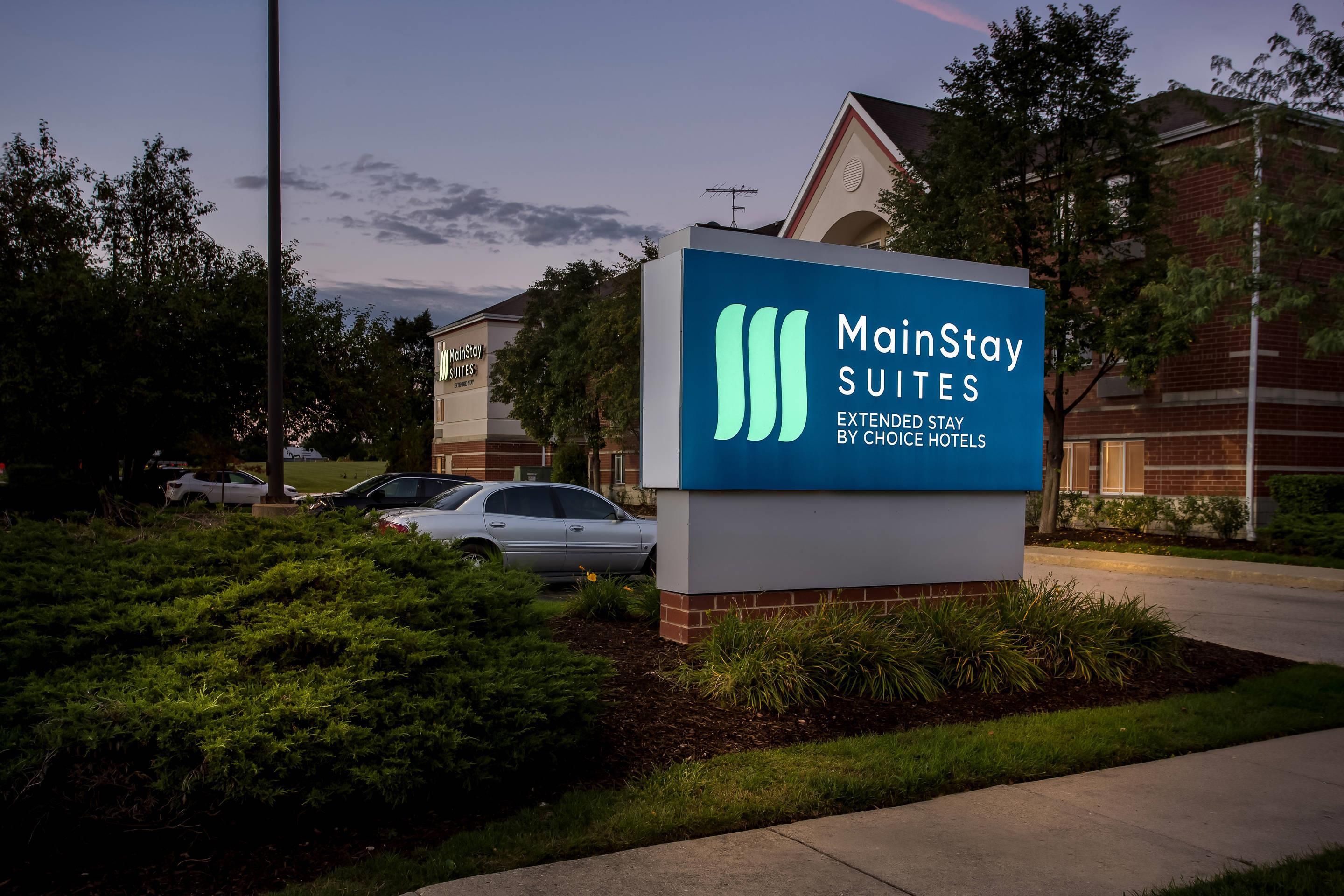 A MainStay Suites sign with a clear view of the hotel building in the background.