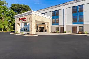 A Hampton Inn by Hilton hotel with a stone facade and a modern design.