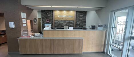 Un comptoir d’accueil avec un revêtement en bois et une enseigne au-dessus.