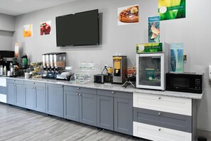 A kitchenette with a microwave, toaster, coffee machine, and various food dispensers. -  Quality Inn & Suites Brooks Louisville South (Brooks)