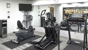 Ein Fitnessstudio mit Laufbändern, Crosstrainern und einem Ergometer.