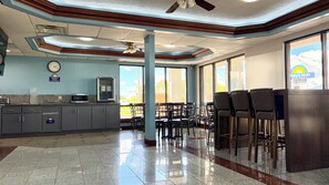 A hotel lobby with a kitchen area, a clock, and a view of the outside. - Days Inn by Wyndham Franklin (Franklin)