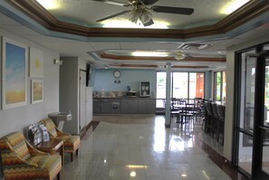 A hotel lobby with a reception desk, seating area, and a kitchenette. - Days Inn by Wyndham Franklin (Franklin)