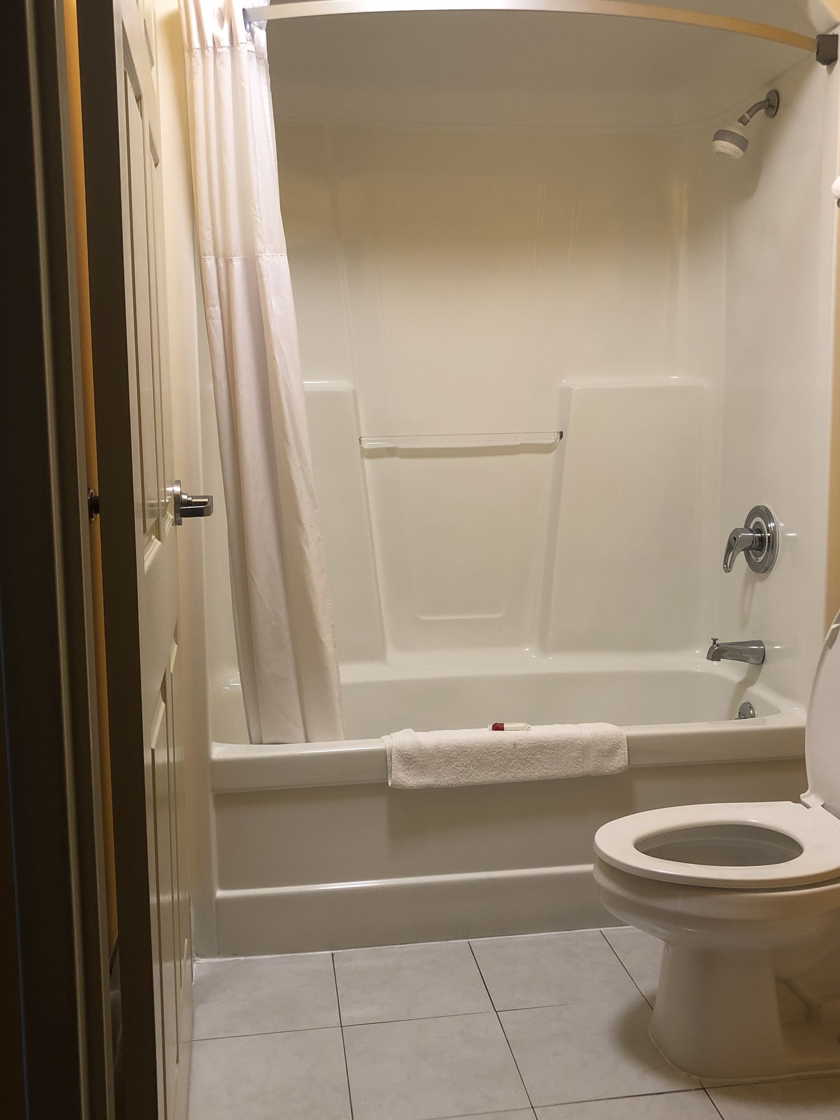 Un baño con bañera, inodoro y cortina de ducha.