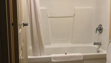 Un baño con bañera, inodoro y cortina de ducha.