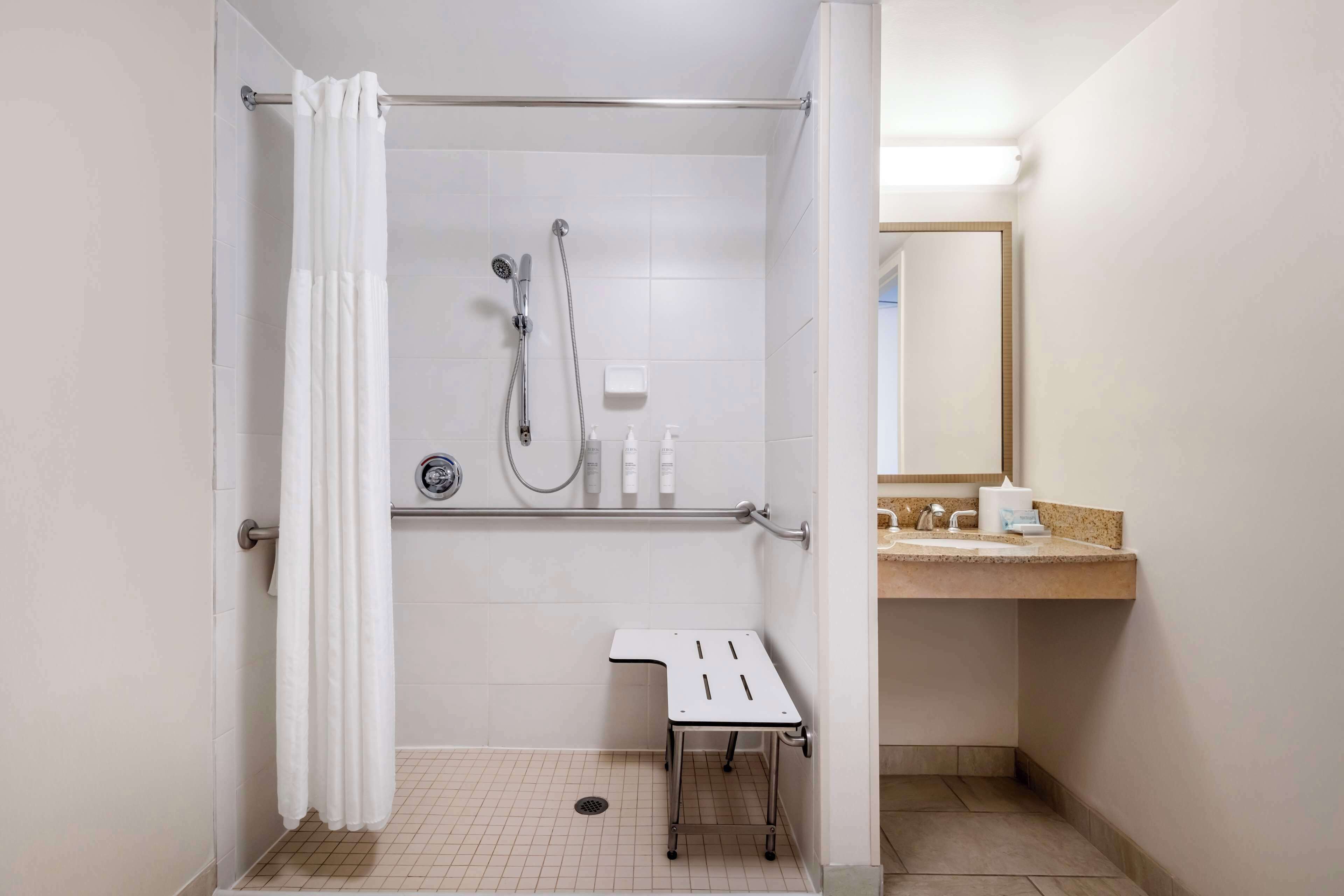 A small, modern bathroom with a shower, a toilet, and a sink.