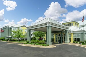 Un hotel con acceso cubierto, aparcamiento y cielo despejado.