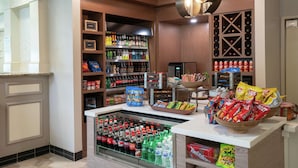 Una tienda de conveniencia bien surtida con estantes llenos de bocadillos, bebidas y productos envasados.