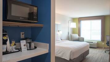 A hotel room with a bed, a microwave, a coffee machine, and a window with a view.