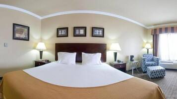 Habitación de hotel con una cama grande, dos mesitas de noche con lámparas, una silla y una ventana con cortinas.