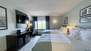 A hotel room with two beds, a desk with a chair, a TV, and a window with curtains. - Wingate by Wyndham Salisbury MD Airport North (Salisbury)