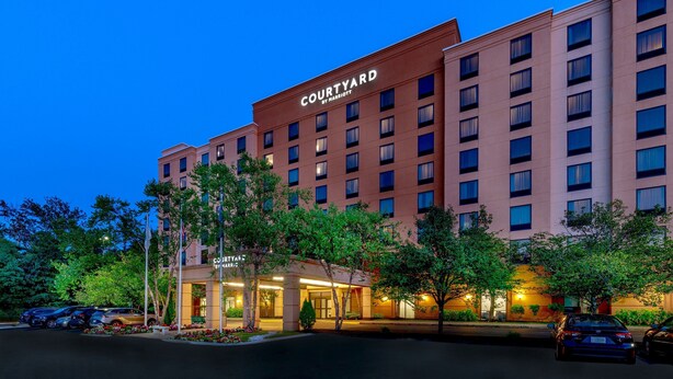 A Courtyard by Marriott hotel with a modern facade, multiple floors, and a well-lit entrance.