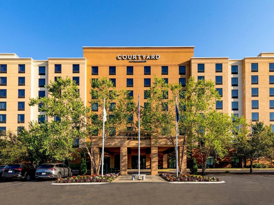 A Courtyard by Marriott hotel with a symmetrical facade, multiple floors, and a central entrance.