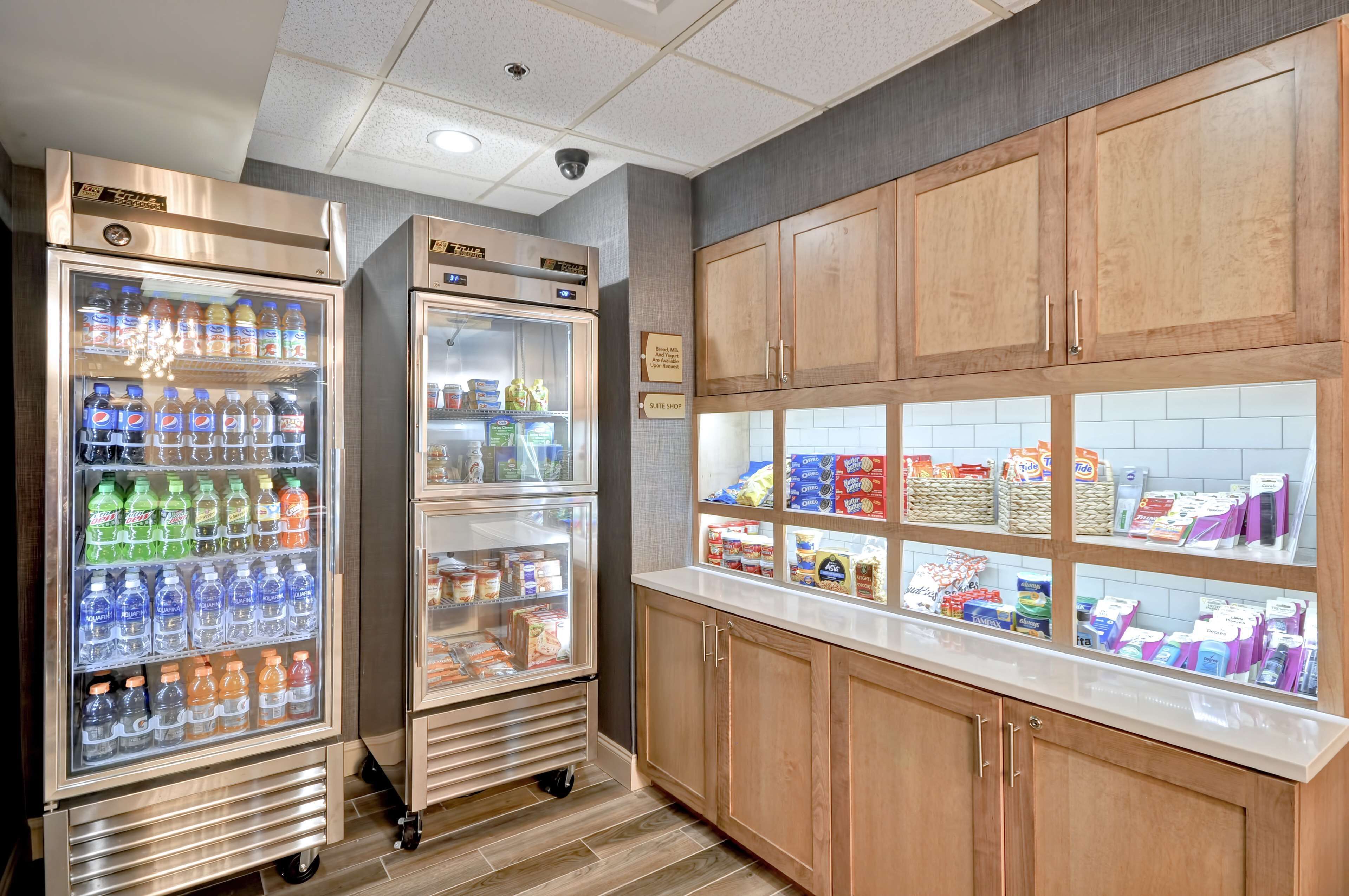 A kitchenette with two beverage dispensers, a bread display, and a variety of packaged goods.
