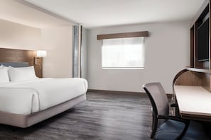A hotel room with a bed, a desk, a chair, a window, and a television. - EVEN Hotel Ann Arbor S - University Area by IHG (Ann Arbor)