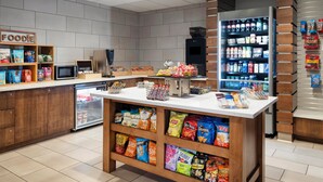 Eine Snackbar mit verschiedenen Speisen, einer Mikrowelle und einem Kühlschrank.