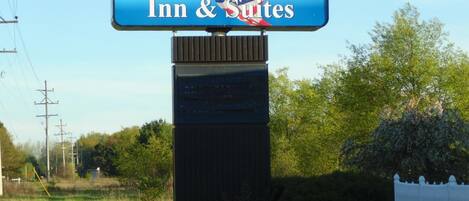 A sign for American Inn & Suites with a clear view of the surrounding landscape.
