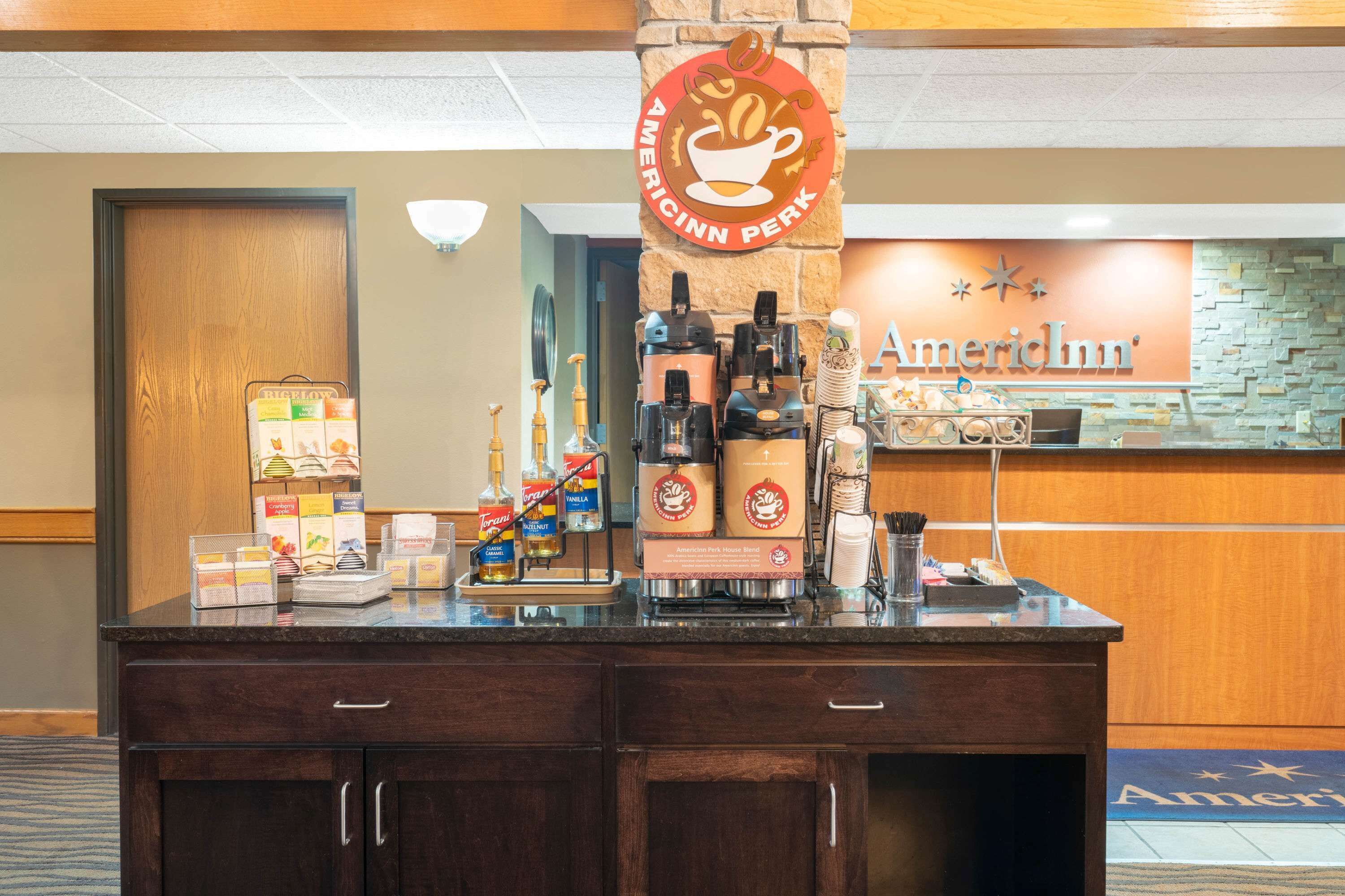 Una estación de café con un letrero que dice "American Inn Perk" y una máquina de café.