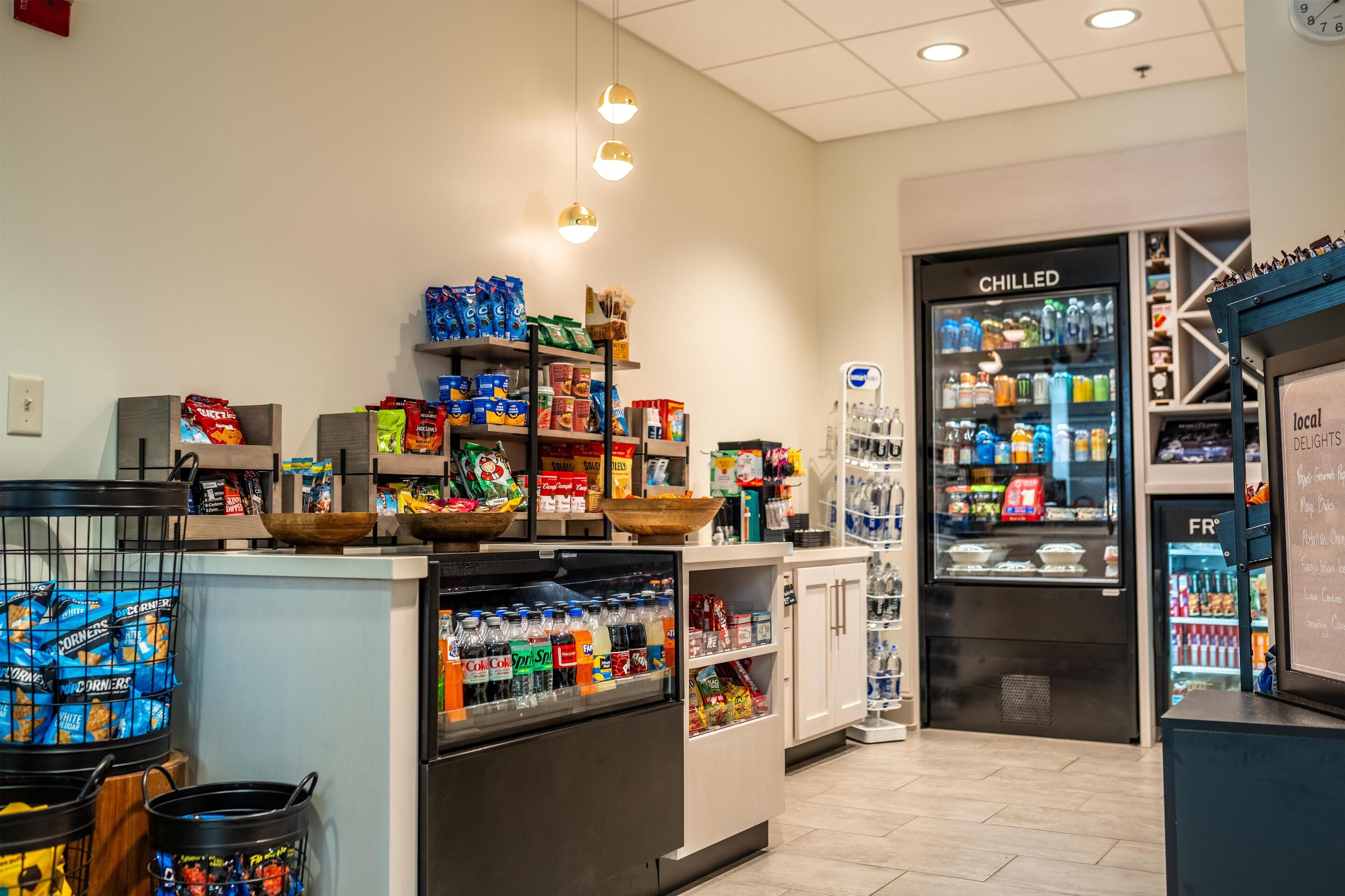 A grocery store with shelves stocked with snacks, beverages, and refrigerated sections.